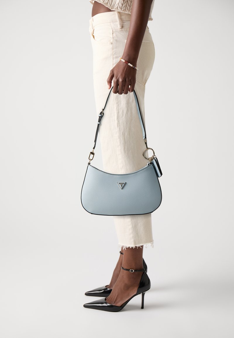 Sac à main en cuir texturé bleu clair, de forme incurvée et avec des bords noirs, arborant un logo en triangle et une bandoulière amovible.