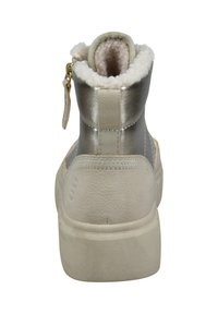 Metallisch silberner Knöchelstiefel mit strukturiertem Finish, cremefarbigem Plüschfutter, braunen Akzenten und einem Reißverschluss hinten. Flache beigefarbene Sohle.