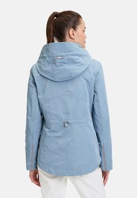 Helle blaue Outdoorjacke mit Kapuze, Kordelzug in der Taille und elastischen Bündchen. Glatte Textur, seitliche Taschen und dezente Details an den Schultern.