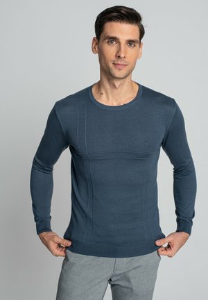 Ciemnoniebieski sweter z długim rękawem, wykonany z teksturowanej dzianiny. Ma okrągły dekolt i dopasowany krój, z delikatnymi szczegółami szycia.