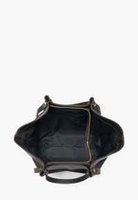 Brązowa torba typu tote z przestronnym wnętrzem wyłożonym czarną tkaniną, wyposażona w kieszeń na zamek i podwójne uchwyty.