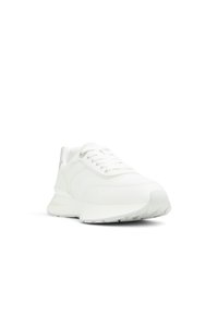 Zapatillas deportivas blancas con parte superior de tela suave, cierre de cordones, cuello acolchado y suela de goma texturizada para mayor agarre.