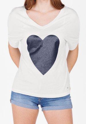White short-sleeve t-shirt with a deep v-neck, featuring a large, textured dark blue heart design on the front.