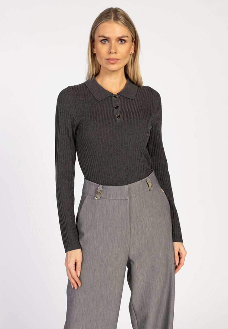 Donkergrijze geribde lange mouwen top met een polokraag en drie knopen, gecombineerd met lichtgrijze high-waisted broek met gouden accenten.