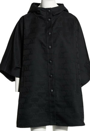Cape noire à capuche avec boutons-pression à l'avant et motif subtil répété "M" sur le tissu, présentée sur un mannequin blanc.
