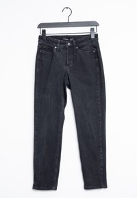 Černé džíny z denimové látky se slim fit střihem, pěti kapsami, kontrastním šitím a zapínáním na knoflík a zip. Visí na černém ramínku.