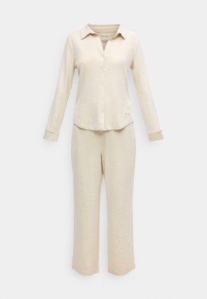 Beige long-sleeve shirt with collar and button closure, paired with matching wide-leg pants. Made of soft, textured fabric.