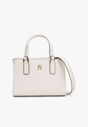 Balta teksturēta ādas rokassoma ar diviem augšējiem rokturiem, regulējamu plecu siksnu un zelta toņa logotipa emblēmu priekšpusē.