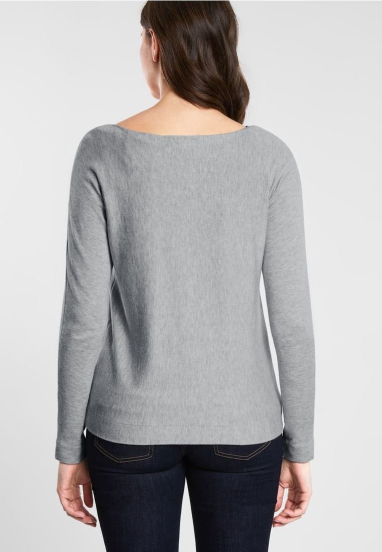 Gray long-sleeve sweater with a wide neckline, made from a soft fabric, features a slightly fitted silhouette and is paired with dark jeans.