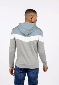 Sudadera con capucha que presenta un diseño a rayas en azul, blanco y gris. Fabricada en tejido suave, con dobladillo y puños acanalados.