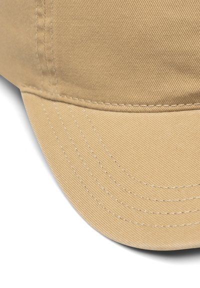 Beige baseball-lippalakki, jossa kaareva lippa ja näkyvät ompeleet paneeleissa ja lippalakissa, lähellä valkoista taustaa.