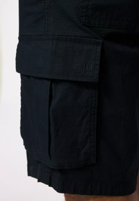Pantalones cortos cargo de color azul oscuro con una tela texturizada, que presentan un gran bolsillo lateral y un logo bordado en la parte delantera.