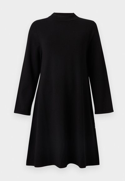 Μαύρο φόρεμα με μακριά μανίκια και στρογγυλή λαιμόκοψη, με ελαφρώς φαρδύ σχήμα σε γραμμή Α, μαλακή υφή και μινιμαλιστικό σχεδιασμό. Χωρίς σχέδια ή διακοσμητικά στοιχεία.