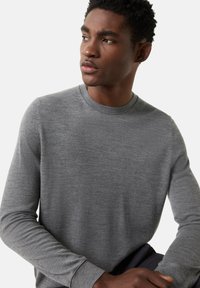 Graues Sweatshirt mit langen Ärmeln, Rundhalsausschnitt und gerippten Bündchen. Glatte Textur, lockere Passform und minimalistisches Design.