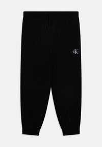 Black jogger pants made of soft fabric, featuring an elastic waistband with drawstring, side pockets, and a small logo patch.