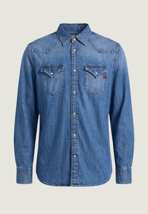 Blå denimskjorte med lange ærmer, trykknapper, to brystlommer med klap og en spids krave, vist på en ensartet lys baggrund.