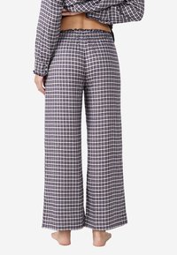 Navy en witte geruite pyjamabroek met een wijde pijp, elastische tailleband en gerimpelde zoom, gemaakt van zacht, lichtgewicht materiaal.