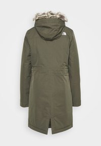 Zielona oliwkowa parka z kapturem wykończonym futrem, długimi rękawami i ściągniętą w talii. Posiada wentylację z tyłu oraz logo na górnej części pleców.
