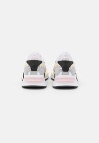 Bílé a šedé tenisky s růžovými a černými akcenty, mají strukturovaný design, polstrovanou podrážku a výraznou podporu paty.