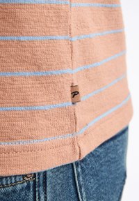 Pfirsichfarbenes Freizeithemd mit hellblauen horizontalen Streifen, strukturiertem Stoff und einem kleinen Logoetikett an der Seitennaht.