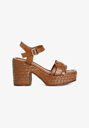 Bruine leren platformsandalen met geweven textuur, dikke blokhak, enkelband met verstelbare gesp en decoratieve strikdetails.