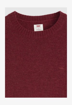 Burgundy crew-neck neulepaita, joka on valmistettu pehmeästä neuloksesta ja jossa on ribbaus kaula-aukossa sekä pieni kohokuvioitu logo rinnassa. Normaali istuvuus.