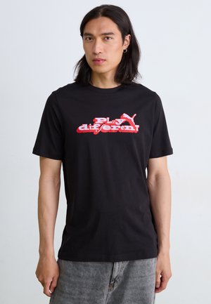 Black cotton t-shirt featuring a red and white graphic text "Play different" and a Puma logo on the front. Short sleeves, crew neck design.