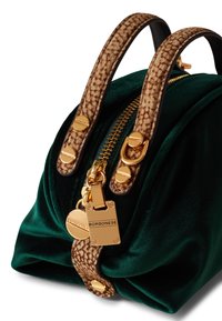 Sac à main vert velours avec des anses texturées marron, matériel doré et fermeture zippée. Présente une étiquette de logo et un design lisse et froncé.