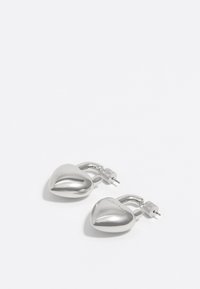 Pendientes en forma de corazón de plata con un acabado metálico pulido, que presentan un cierre de poste y curvas suaves.