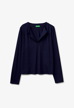 Granatowa koszula z długim rękawem, z luźnym otwartym kołnierzem i małą zieloną metką wewnątrz linii szyi.