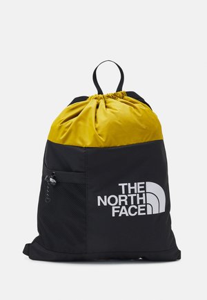 Plecak na sznurki z żółtą górą i czarnym dołem, z przednią siateczkową kieszenią i białym logo The North Face.