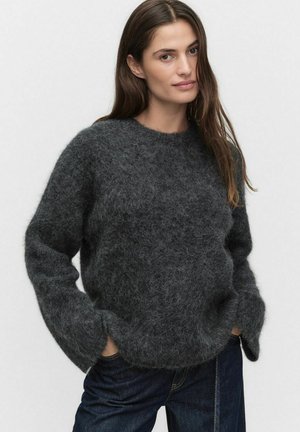 Mörkgrå ulltröja med rund halsringning, lös passform och texturerad, fluffig yta. Långa ärmar och sänkta axelsömmar.