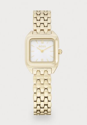 Montre bracelet rectangulaire en or avec un cadran blanc, présentant des chiffres romains aux positions 12 et 6, et un bracelet en métal à maillons. Le logo de la marque est affiché.