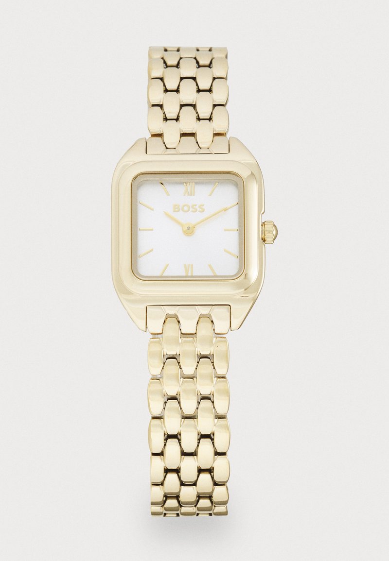 Montre bracelet rectangulaire en or avec un cadran blanc, présentant des chiffres romains aux positions 12 et 6, et un bracelet en métal à maillons. Le logo de la marque est affiché.