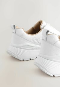 Hvide lædersneakers med tekstureret overflade, kurvet design, polstret beige inderside og en tab ved hælen for nem påtagning.