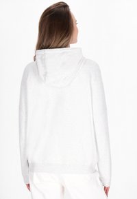 Lichtgrijze hoodie met een losse pasvorm, zachte textuur en brede mouwen, voorzien van een geribbelde zoom en manchetten.