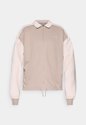 Nike ziplock-jakke i beige med lyserøde ærmer, med krave, elastiske manchetter og snoretræk i kanten. Broderet logo på brystet.