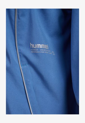 Blauw gestructureerde stof met reflecterende bies en "hummel" logo, inclusief tekst "Techwear ontwikkeld door HMI, performance sportkleding sinds 1923."