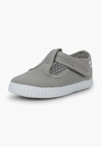 Scarpa slip-on in tela grigia con fascia elastica, suola in gomma bianca e fodera interna a scacchi. Presenta punta rotonda e cuciture rinforzate.