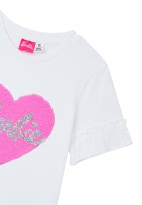 T-shirt bianco con un grande cuore di paillettes rosa e la parola "Barbie" in argento. Maniche corte e arricciate aggiungono dettagli al design.
