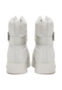 Svijetlosivi gležnjači od gladak sintetički materijal, s eks elasticnim trakama i masivnom petom s teksturiranim gripom.