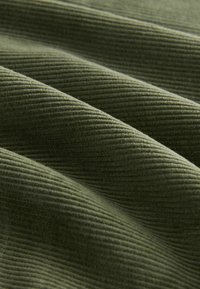 Material de culoare verde măsliniu cu o textură în dungi, prezentând linii paralele moi și o senzație ușor pufoasă, creând adâncime și interes vizual.