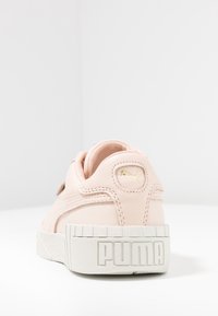 Baskets en cuir rose avec surface texturée, semelle en caoutchouc blanche et logo Puma doré sur le talon. Comprend des accents cousus et un design arrondi.