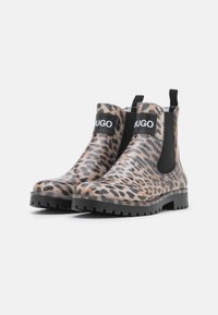 Botines de goma hasta el tobillo con estampado de leopardo, panel lateral elástico negro y tiradores, con una parte superior estampada y suela negra resistente.