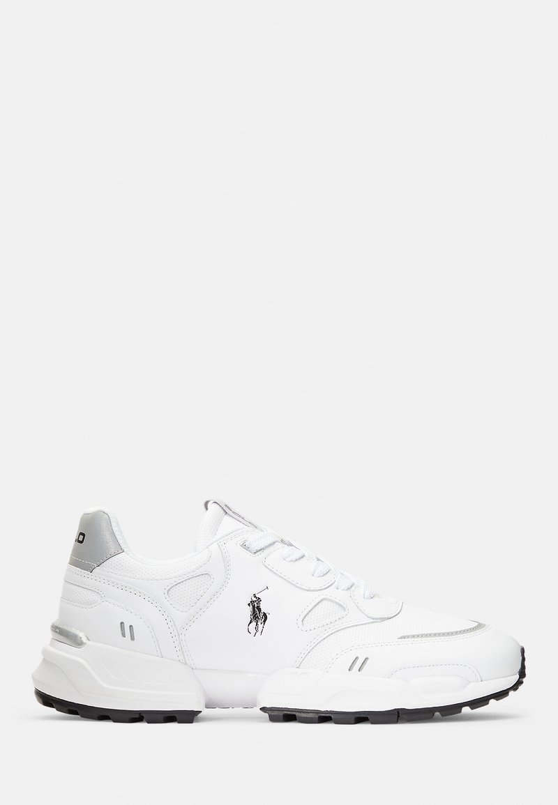 Zapatillas deportivas blancas con una parte superior de cuero texturizado, cuello acolchado, acentos grises y una suela de goma negra. Presenta un logo en el lateral.