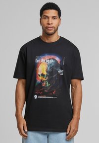 Sort t-shirt lavet af bomuld, med et farverigt kraniumgrafik og teksten "PRAY for the dead" samt en lyseblå accent. Korte ærmer og rund hals.