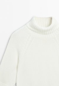 White knitted short-sleeve sweater with a ribbed high neck collar and subtle textured pattern along the sleeves and shoulders.