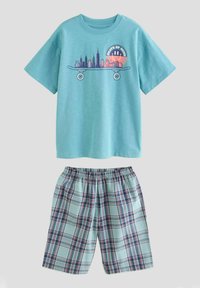 Ljusblå bomullströja med skateboardgrafik och stads skylten. Rutig shorts i ljusblått, marinblått och rött med elastisk midja.
