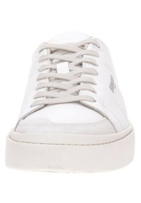 Sneaker bianco con lacci, realizzato in pelle liscia, con una texture sottile, punta rotonda e una suola bianca spessa e imbottita. Dettagli del logo sul lato.