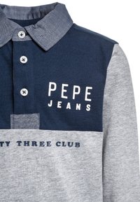 Námořnická a šedá bavlněná polo košile s jemným límcem, s bílým textem "PEPE JEANS" a tiskem "THREE CLUB". Detail knoflíku poblíž výstřihu.